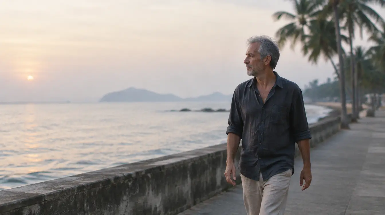 A man in his late fifties walking along a seaside promenade at dawn